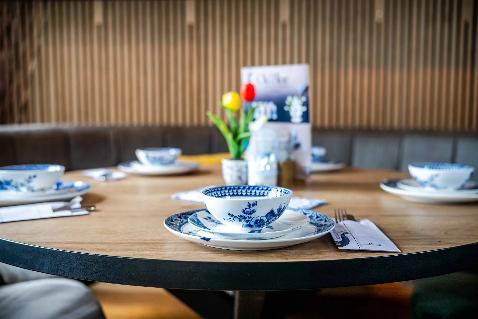 Gedekte ronde tafel met Heinen Delftsblauw servies en tulpen bij Old Blue Giethoorn