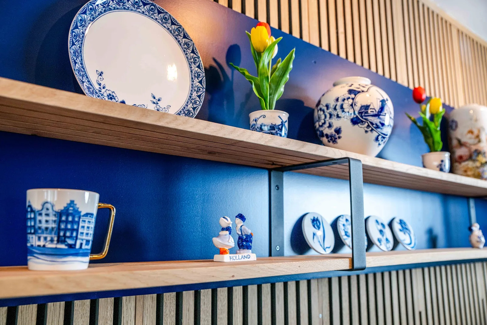 Houten wandplanken met Heinen Delftsblauw aardewerk in het restaurant
