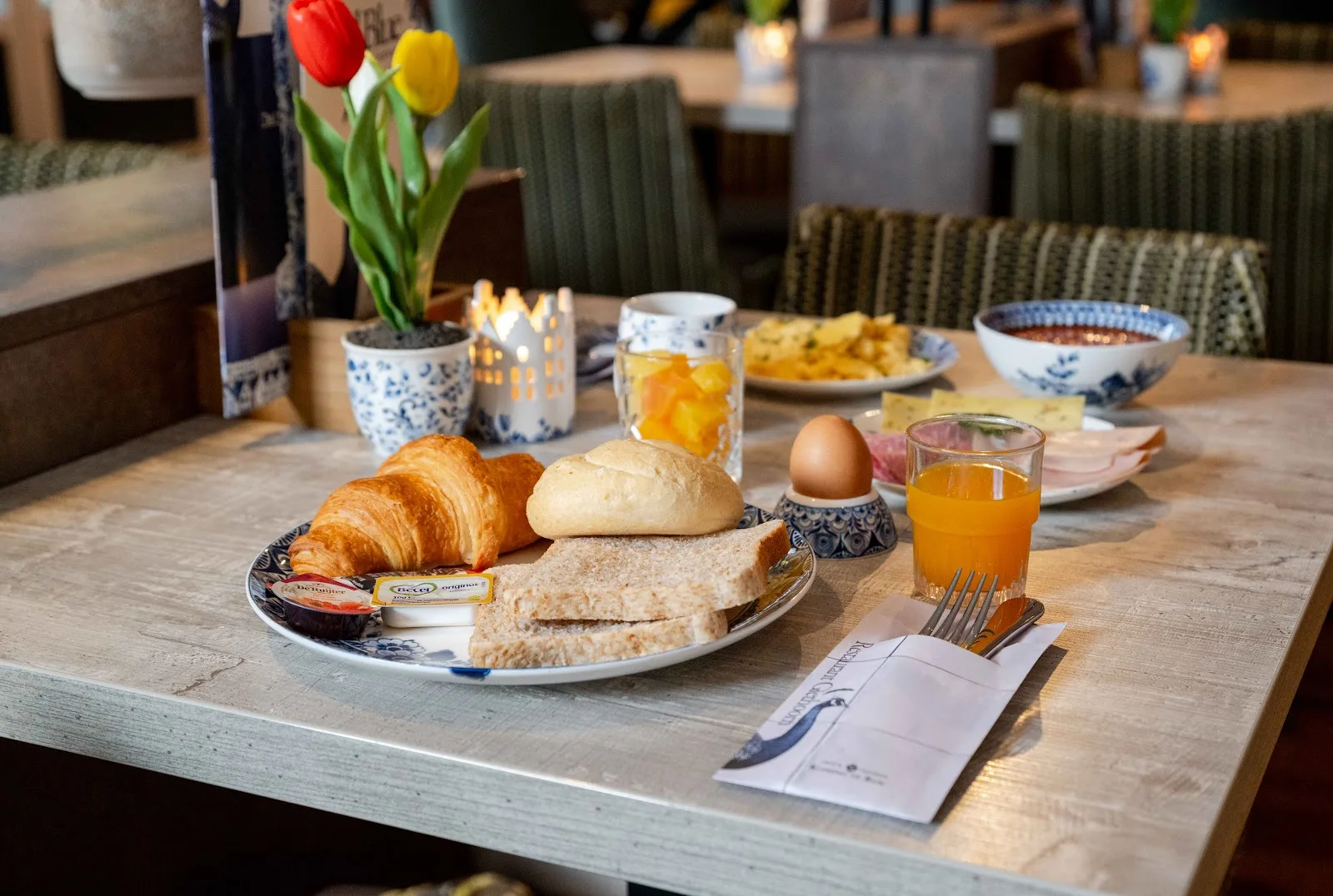 Uitgebreid Nederlands ontbijt met croissant, broodje, ei en jus d'orange